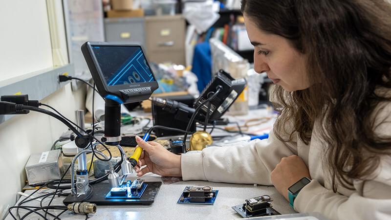 CEMS graduate student building a circuit board in an electrical and computer engineering lab